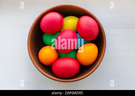 Ostereier in brauner Schüssel. Frohe Osterferien. Bunt bemalte Eier. Hell gekochte Eier. Traditionelle Osterdekoration. Christlicher Feiertag. Stockfoto