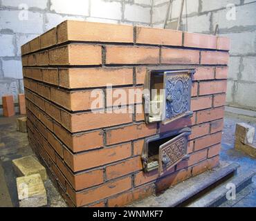 Bau von Ziegelöfen. Backsteinofen für Sauna. Heizsteinofen. Stockfoto