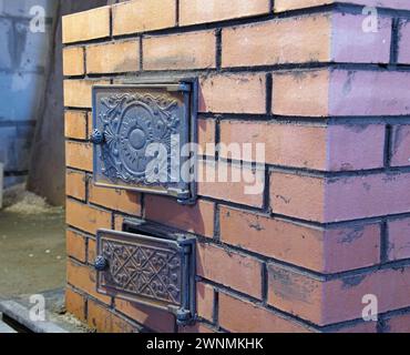 Bau von Ziegelöfen. Backsteinofen für Sauna. Heizsteinofen. Stockfoto