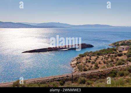 Wunderschöne Landschaft in der Region Attika mit Blick auf die Bucht der Insel Salamina und das Schiffswrack eines gekenterten Schiffes, das in den frühen 2000er Jahren im seichten Wasser versank Stockfoto