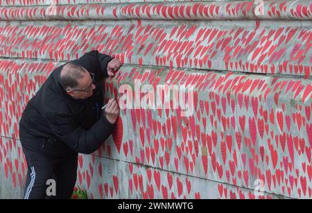 London, England, Großbritannien. März 2024. Am Nationalfeiertag der Reflexion versammeln sich Menschen entlang der COVID-Gedenkmauer am Themsenpfad in Westminster zu Ehren derer, die während der COVID-19-Pandemie starben. Jedes handgemalte Herz an der Wand repräsentiert ein Leben, das in Großbritannien an COVID-19 verloren ging. (Kreditbild: © Tayfun Salci/ZUMA Press Wire) NUR REDAKTIONELLE VERWENDUNG! Nicht für kommerzielle ZWECKE! Stockfoto