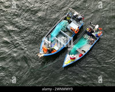 Viana do Castelo, Portugal - 3. März 2024: Fischer legen ein Netz über den Fluss Lima Stockfoto