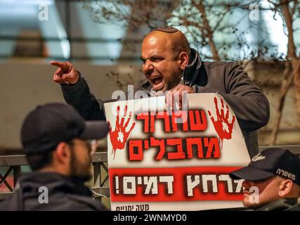 Jerusalem, Israel. März 2024. Zehntausende von Menschen nahmen an einer Demonstration Teil, in der die israelische Regierung aufgefordert wurde, eine Vereinbarung mit der Hamas zu erzielen, die die Geiseln nach Hause zurückbringen würde. Auf der anderen Straßenseite hielt ein einziger Demonstrant ein Schild: "Die Freilassung von Terroristen wird zu einem Blutbad führen". Er argumentierte, dass die Geiseln nur bei militärischen Operationen freigelassen werden sollten. Quelle: Yoram Biberman/Alamy Live News. Stockfoto