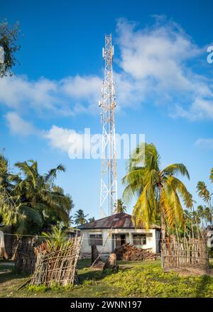 Ein kleines Haus mit Funkgerät und Handymast dahinter, Jambiani, Sansibar, Tansania Stockfoto