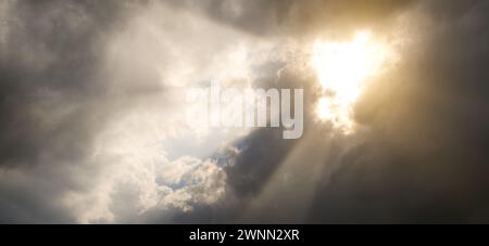 Sonnenstrahlen durch schwarze Sturmwolken. Stockfoto