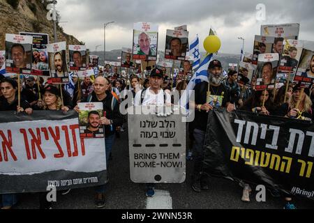 Jerusalem, Israel. März 2024. Israelische Geiselfamilien tragen die Fotos ihrer Angehörigen, die von der Hamas in Gaza als Geiseln festgehalten werden, während sie nach Jerusalem marschieren. Familien der 134 israelischen Geiseln marschieren nach Jerusalem mit den Fotos ihrer Lieben, die 148 Tage lang in Gefangenschaft der Hamas im Gazastreifen gehalten wurden. Tausende Israelis marschieren in ihren viertägigen Protesttagen vom Parteigelände Nova zu einer Zeremonie in Jerusalem, während Gespräche über einen Waffenstillstand und Geiselabkommen stattfinden. (Credit Image: © Matan Golan/SOPA Images via ZUMA Press Wire) NUR REDAKTIONELLE VERWENDUNG! Nicht für kommerzielle ZWECKE! Stockfoto