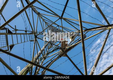 Abstrakte Ansicht einer hoch aufragenden Radarstruktur mit komplizierten Metallarbeiten unter klarem Himmel Stockfoto