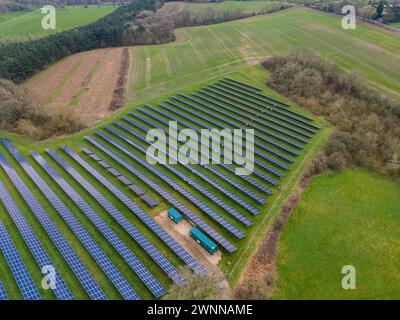 Hochwinkelaufnahme mit einer großen Auswahl an Solarpaneelen zwischen grünen Feldern Stockfoto