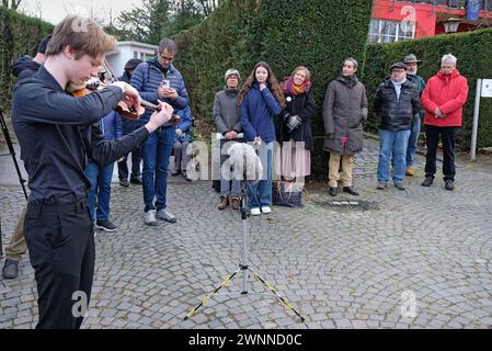 Stolpersteinverlegung für Familie ganz Aachen, 01.03.2024: Der junge Geiger Till Stümke, Schüler der Viktoriaschule spielt das Stück jüdisches Lied von Ernst Bloch. Stolpersteinverlegung an der Eupenerstr. 249. Charles Antosiewicz im Bild war mit seiner Schweizer Familie angereist. Sein Großvater Otto ganz 1879-1944, seine Tante Erika ganz 1911-1943 und seine Urgroßmutter Regine Grüneberg 1858-1942 hatten hier gelebt. Sie wurden deportiert und ermordet. Innerhalb der Aktion Stolpersteine des Künstlers Gunter Demnig wurden vom Gedenkbuch-Projekt für die Opfer der Shoah aus Aachen e.V. drei Stolper Stockfoto