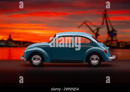 Göteborg, Schweden - 27. Februar 2024: Blauer Volkswagen Käfer Spielzeugwagen auf Sonnenuntergang Hintergrund Stockfoto