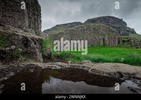 Basaltsäulen erheben sich aus dem Boden in island, in der Nähe von foss, einem Sidu-Wasserfall im südlichen Teil. Die Reflexion von Säulen im kleinen Wasserteich. Stockfoto