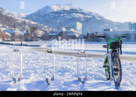 Leihfahrräder in Bergen, Norwegen an einem sonnigen Wintertag. Fahrradständer mit Leihfahrrad bedeckt und von Schnee umgeben. In der Nähe des Sees im Zentrum von Bergen, Single BI Stockfoto