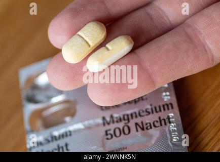 Berlin, Deutschland. März 2024. Ein Mann hält zwei Magnesiumtabletten in der Hand. Quelle: Monika Skolimowska/dpa/Alamy Live News Stockfoto