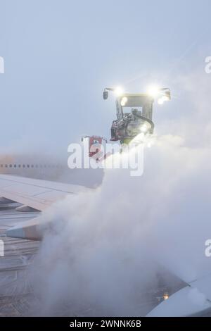 Enteisung oder Enteisung eines Luftfahrzeugs vor dem Start. Sicherheitsmaßnahmen bei kalten Umgebungstemperaturen am Flughafen, um ein Einfrieren der Kontrollflächen zu verhindern. Stockfoto