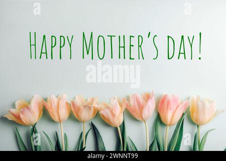 Gelb-rosa Tulpen auf hellgrünem Hintergrund mit Worten Happy Mother's Day. Stockfoto