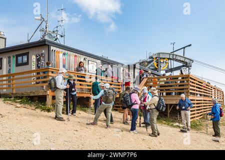 Touristen, die sich auf eine Bergwanderung vom Restaurant Corbet's Cabin in in der Nähe der Spitze der Jackson Hole Aerial Tram Ride oberhalb von Jackson, Wyoming, vorbereiten Stockfoto
