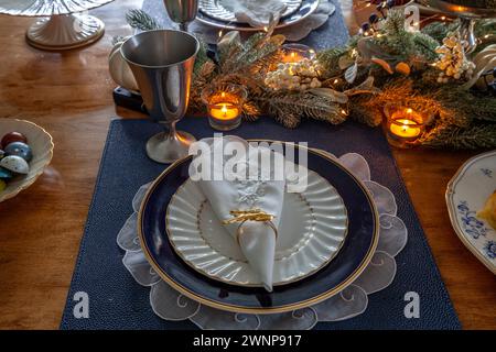 Weihnachtliches Ambiente und Grün auf einem Tisch mit feinem Knochenporzellan. Stockfoto