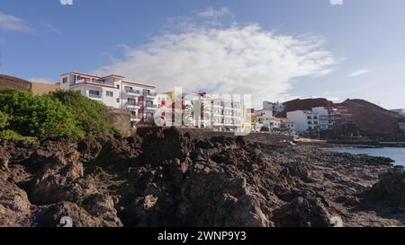 Sonnenverwöhnte Luxushäuser mit Blick auf türkisfarbenes Wasser und zerklüftete Klippen. Stockfoto