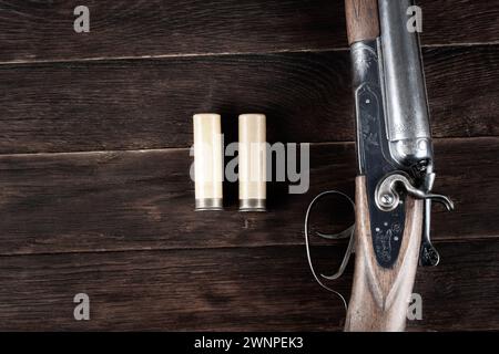 12 Gauge Break Action glatte, gebohrte Schrotflinte mit Papierpatronen auf Holztisch. Stockfoto