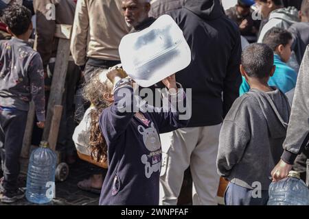 Rafah, Gazastreifen, Palästinensische Gebiete. März 2024. Die Palästinenser sammeln Wasser aus einer Wassertankstelle, wo die Menschen aufgrund des Krieges unter Wasserknappheit leiden. Die Gesamtzahl der Todesopfer in Gaza hat seit Beginn des Krieges am 7. Oktober 30.000 überschritten, so das Gesundheitsministerium des Streifens. Auch in dieser Woche wurden weitere Details über eine mögliche neue Waffenstillstandsvereinbarung bekannt, die vor dem Ramadan beginnen könnte, bis weitere Verhandlungen zwischen Israel, Hamas und ausländischen Mittlern abgeschlossen sind. (Kreditbild: © Saher Alghorra/ZUMA Press Wire) NUR REDAKTIONELLE VERWENDUNG! Nicht für kommerzielle ZWECKE! Stockfoto