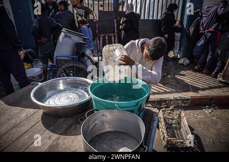 Rafah, Gazastreifen, Palästinensische Gebiete. März 2024. Die Palästinenser sammeln Wasser aus einer Wassertankstelle, wo die Menschen aufgrund des Krieges unter Wasserknappheit leiden. Die Gesamtzahl der Todesopfer in Gaza hat seit Beginn des Krieges am 7. Oktober 30.000 überschritten, so das Gesundheitsministerium des Streifens. Auch in dieser Woche wurden weitere Details über eine mögliche neue Waffenstillstandsvereinbarung bekannt, die vor dem Ramadan beginnen könnte, bis weitere Verhandlungen zwischen Israel, Hamas und ausländischen Mittlern abgeschlossen sind. (Kreditbild: © Saher Alghorra/ZUMA Press Wire) NUR REDAKTIONELLE VERWENDUNG! Nicht für kommerzielle ZWECKE! Stockfoto