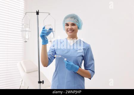 Krankenschwester, die IV-Tropf im Krankenhaus einrichtet Stockfoto