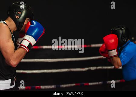 Zwei Boxer stehen ihren Wachen gegenüber, die bereit sind, zu kämpfen. Stockfoto