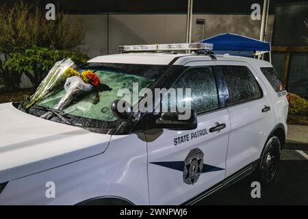 Marysville, Usa. März 2024. Blumen zieren das Denkmal für Trooper Christopher Gadd im Hauptquartier der Washington State Patrol in Marysville und dienen als ergreifende Hommage an sein Andenken. Die Kollision, die in der Nähe der 136th Street Northeast kurz vor 3 Uhr morgens stattfand, löste eine sofortige Reaktion der Sheriffs von Snohomish County aus. Der Soldat, genannt Christopher Gadd, im Alter von 27 Jahren, erlag tragischerweise seinen Verletzungen am Tatort. Gadd, der 2,5 Jahre bei der Staatspatrouille gedient hatte, war in Marysville stationiert. Quelle: SOPA Images Limited/Alamy Live News Stockfoto