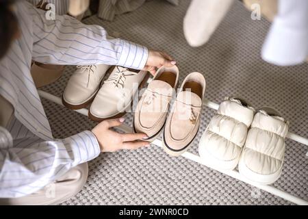 Moderne Frau, die Schuhe wählt, Regalgarderobe Kleiderschrank bequeme Aufbewahrung, die Sicht von oben organisiert Stockfoto