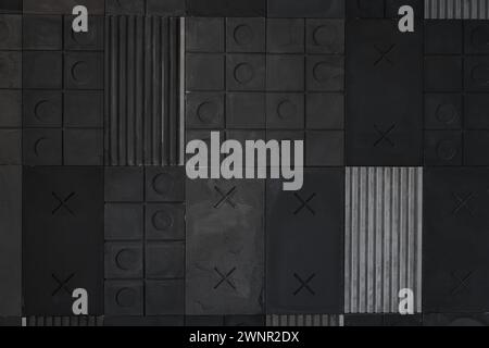 Strukturierter schwarzer, grauer geometrischer Hintergrund aus Beton mit Streifen, Quadraten, Kreisen, Kreuzen, Tic-Tac-Toe, Kopierbereich. Konzept moderner abstrakter kreativer Wandgestaltung mit voluminösen konvexen Elementen. Stockfoto