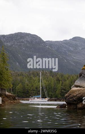 Ein wunderschönes Segelboot in einem abgelegenen Ankerplatz mit Bergen im Hintergrund, Zentralküste von British Columbia, Kanada Stockfoto