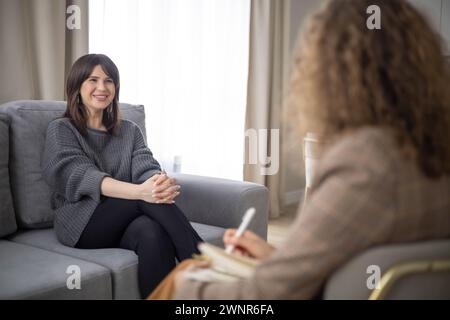 Psychologin spricht bei Psychotherapiesitzung mit Patientenberatung und macht Notizen im Büro Stockfoto