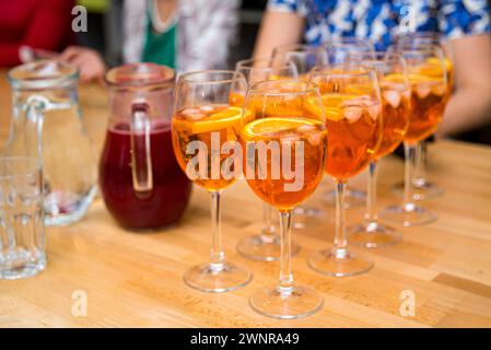 Erfrischende Aperol Spritz Cocktails in Weingläsern, garniert mit Orangenscheiben, perfekt für ein geselliges Treffen oder eine Party. Stockfoto