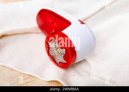 Fusselentferner auf weißem Wollkleid Stockfoto