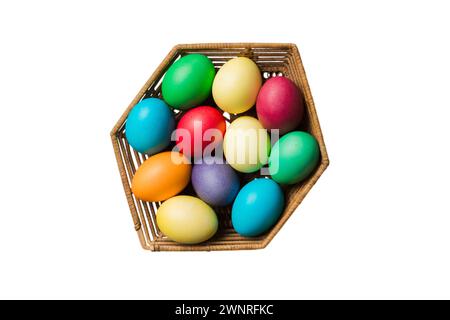 Korb mit bunten Ostereiern, isoliert auf weißem Hintergrund. Osterkorb gefüllt mit farbigen Eiern Top View Urlaubskonzept. Stockfoto