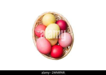 Korb mit bunten Ostereiern, isoliert auf weißem Hintergrund. Osterkorb gefüllt mit farbigen Eiern Top View Urlaubskonzept. Stockfoto