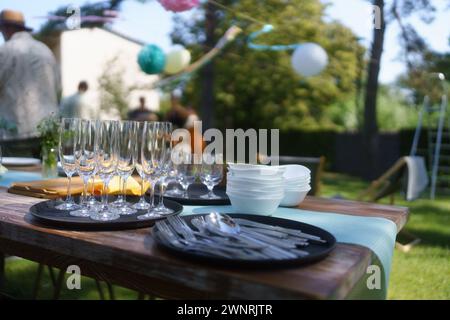 Nahaufnahme leerer Weingläser, Besteck und Utensilien bei der Gartenparty im Sommer. Stockfoto