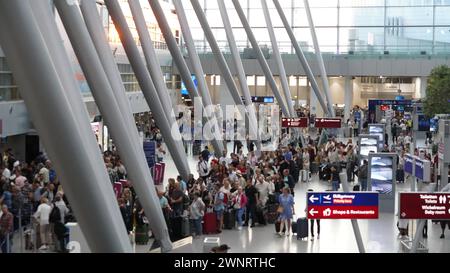 Flughafen Düsseldorf, Nordrhein Westfalen, Deutschland Europa - Impressionen am Flughafen - Warteschlangen am Check-in im Terminal und genervte Urlauber Symbolbild: Gepäckabgabe, Flugsteig, Flugzeug, Abflug, Ankunft, Flugplan, Reisevorbereitung, Flughafenpersonal, Gate, Verspätung, Reisegruppe, Passkontrolle, Zollkontrolle, Gepäckband, Flughafenlounge, Duty-Free-Shop, Sicherheitspersonal, Boarding-Prozess, Flughafenbus, Rolltreppe, Gepäckwagen, Flugreisender, Reisegepäck, Reisepasskontrolle, Flugverspätung, Terminalgebäude, Passagierabfertigung, Flugziel, Flughafenterminal, Anzeigetafel, Reise, Stockfoto