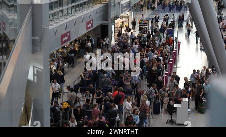 Flughafen Düsseldorf, Nordrhein Westfalen, Deutschland Europa - Impressionen am Flughafen - Warteschlangen am Check-in im Terminal und genervte Urlauber Symbolbild: Gepäckabgabe, Flugsteig, Flugzeug, Abflug, Ankunft, Flugplan, Reisevorbereitung, Flughafenpersonal, Gate, Verspätung, Reisegruppe, Passkontrolle, Zollkontrolle, Gepäckband, Flughafenlounge, Duty-Free-Shop, Sicherheitspersonal, Boarding-Prozess, Flughafenbus, Rolltreppe, Gepäckwagen, Flugreisender, Reisegepäck, Reisepasskontrolle, Flugverspätung, Terminalgebäude, Passagierabfertigung, Flugziel, Flughafenterminal, Anzeigetafel, Reise, Stockfoto