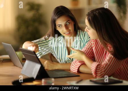 Zwei Telearbeiter reden nachts zu Hause über Arbeit Stockfoto