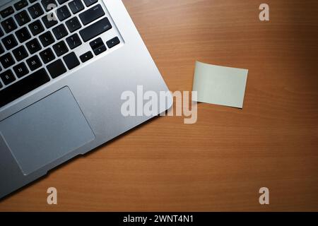 Ein Büroschreibtisch mit Laptop und Haftnotizpapier. Holzhintergrund mit Kopierraum. Stockfoto