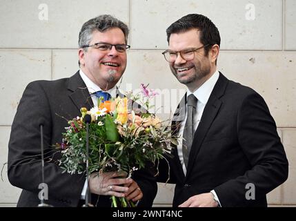 Karlsruhe, Deutschland. März 2024. Bundesjustizminister Marco Buschmann (r, FDP) überreicht dem neuen Generalstaatsanwalt Jens Rommel bei seiner offiziellen Amtseinführung einen Blumenstrauß. Quelle: Uli Deck/dpa/Alamy Live News Stockfoto