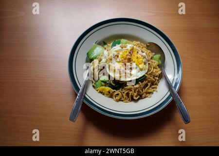 Mie Goreng Telor, traditionelles indonesisches Streetfood, gebratene Nudeln mit Ei mit typischen Gewürzen der javanischen Küche. Stockfoto