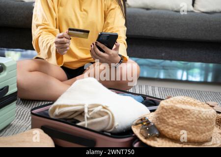 Junge Frau, die online mit Kreditkarte per Smartphone bezahlt. Stockfoto