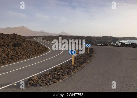 Straße entlang Los Hervideros, zerklüftete vulkanische Küste, bekannt für Wellen, die in Meereshöhlen stürzen und malerische Ausblicke. Stockfoto