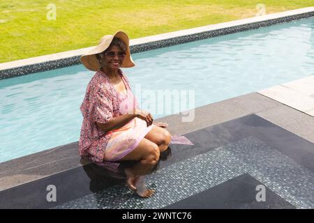 Seniorenfrau genießt Entspannung am Pool, mit Kopierraum Stockfoto