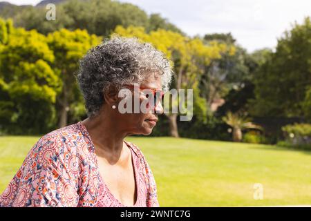 Ältere birassische Frau mit grauem Haar genießt einen sonnigen Tag im Freien mit Kopierraum Stockfoto