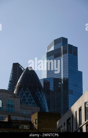 Die Wolkenkratzer der City of London, vom Powell Way aus gesehen: Das geschwungene Gebäude ist 30 Saint Mary Axa, auch bekannt als The Gherkin, und das höhere Gebäude in Stockfoto