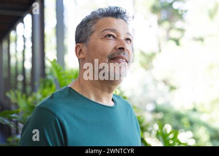 Ein älterer birassischer Mann mit grauen Haaren sieht nachdenklich aus, steht draußen Stockfoto