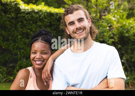 Ein vielseitiges Paar, eine junge Afroamerikanerin und ein junger Kaukasier, lächeln draußen Stockfoto
